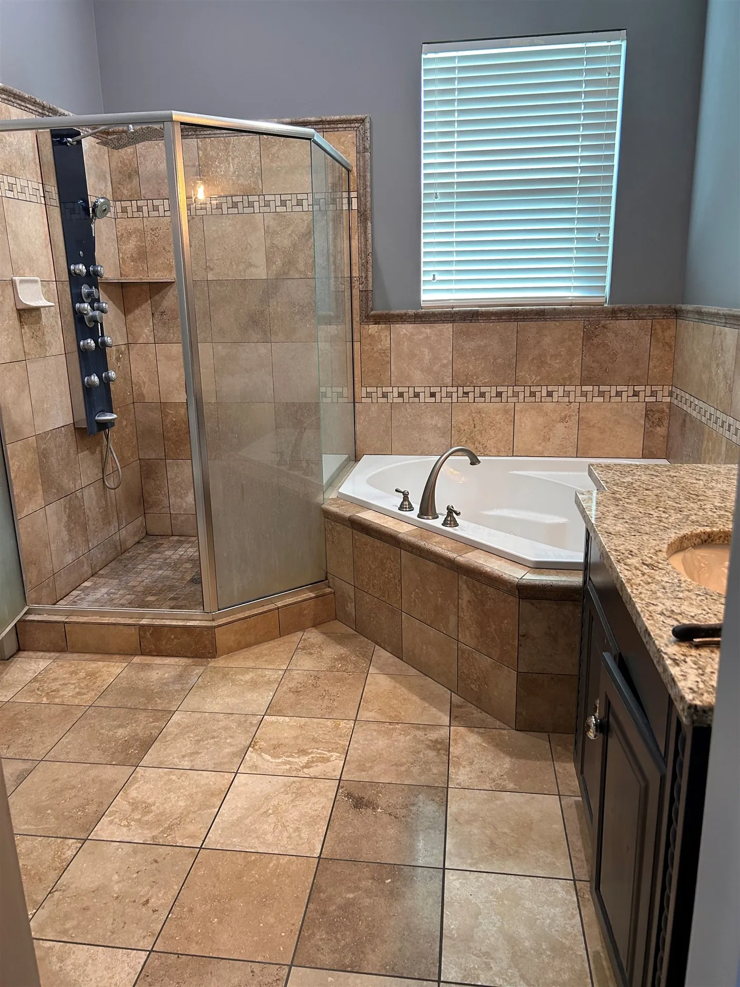 Corner tub and shower with travertine tile