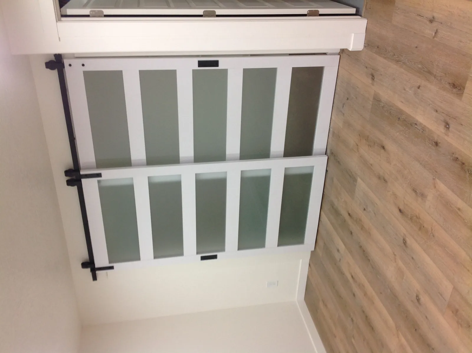 Frosted glass barn-style shower door on wood-look floor