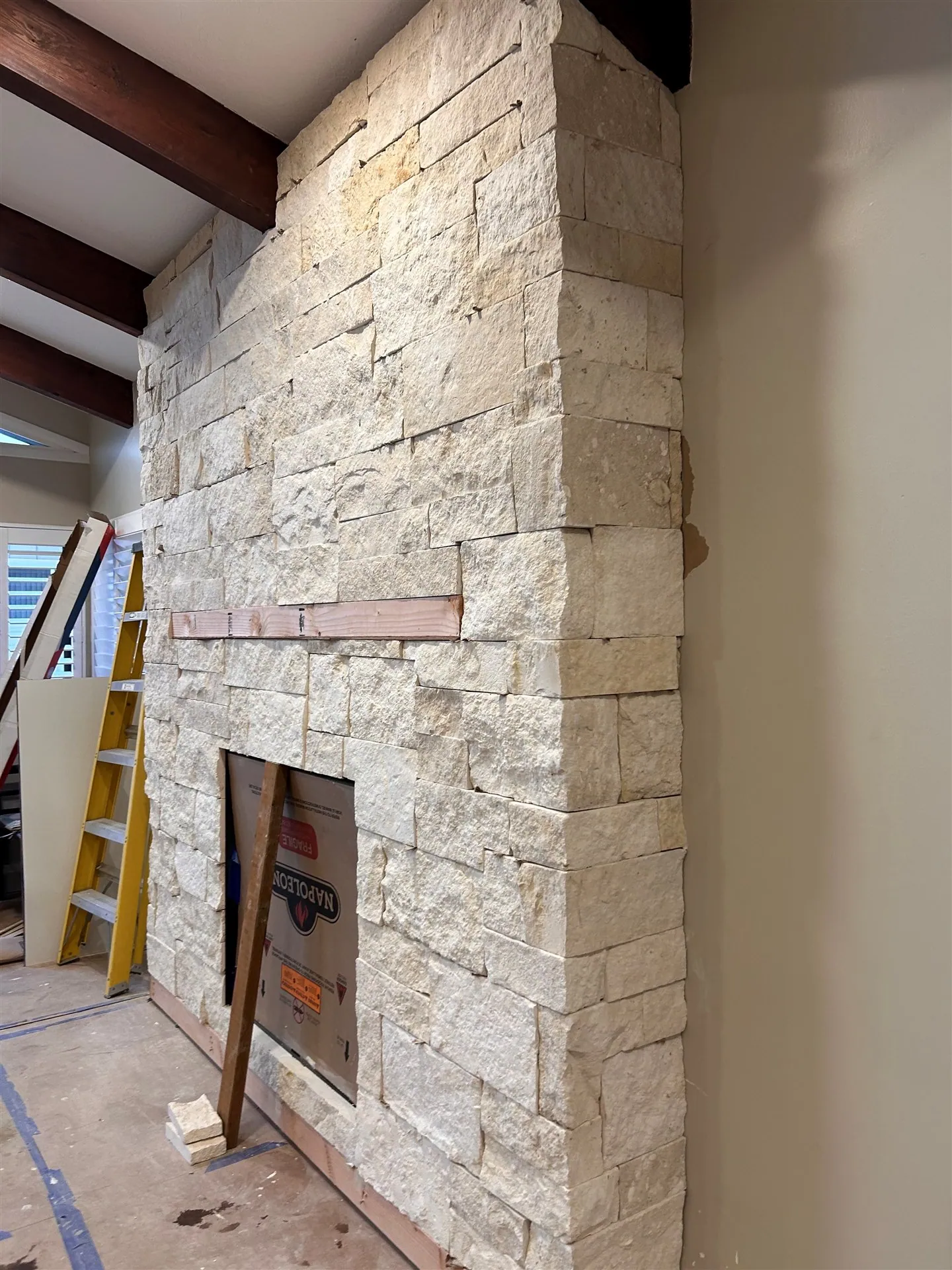 Stacked stone fireplace surround under construction