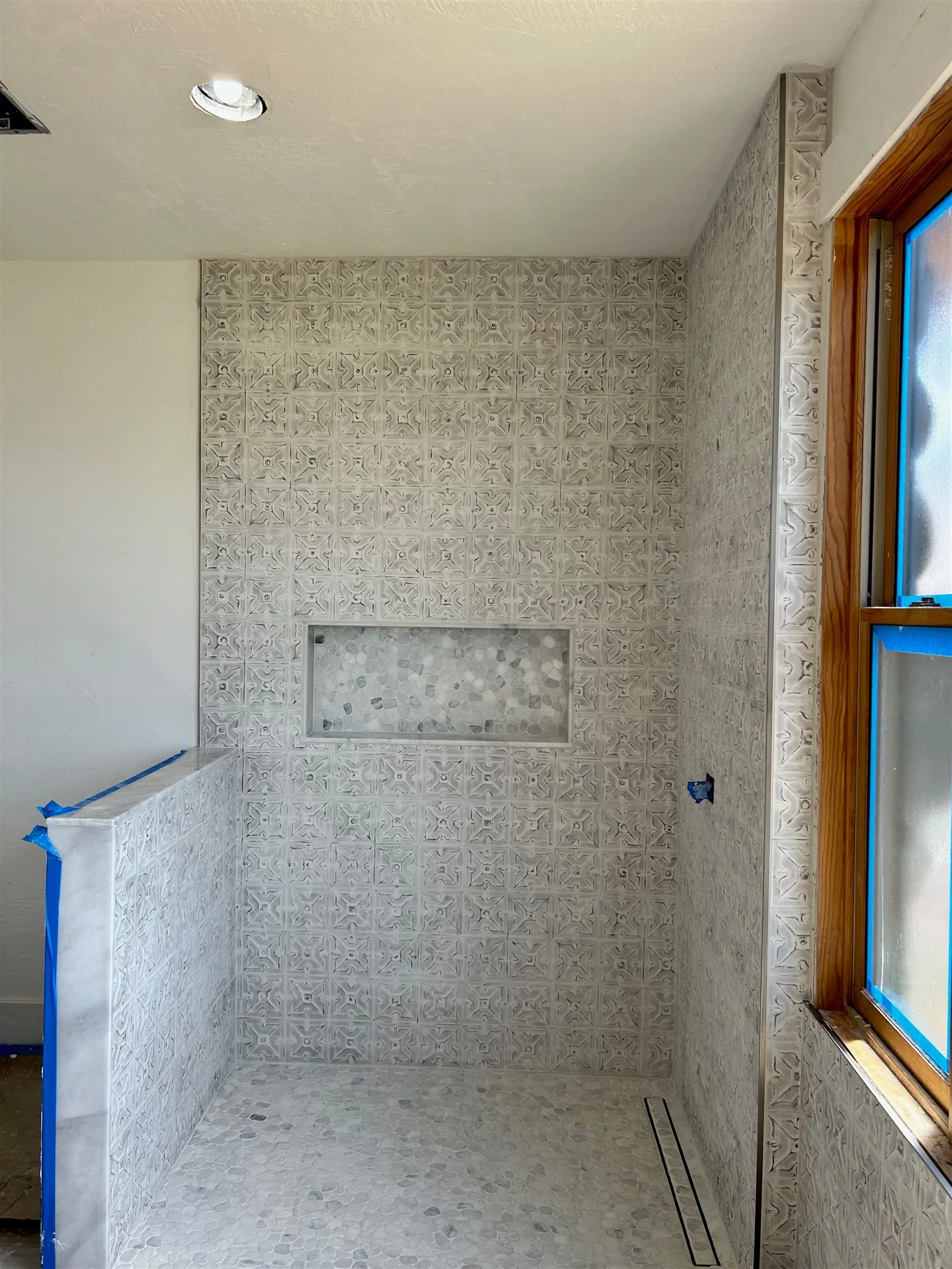 Neutral tile shower with recessed niche and linear drain