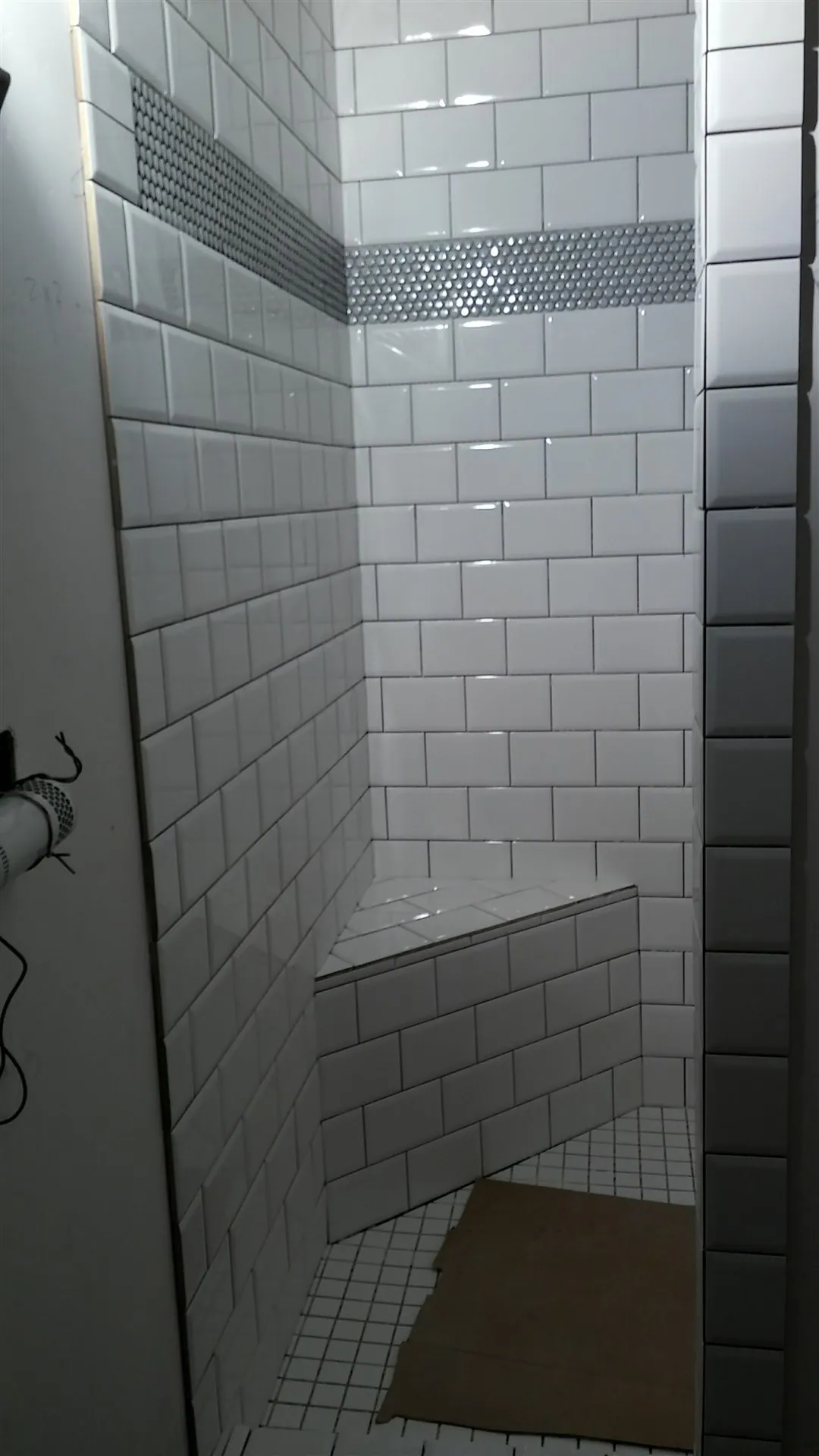 Subway tile shower with mosaic accent stripe and bench