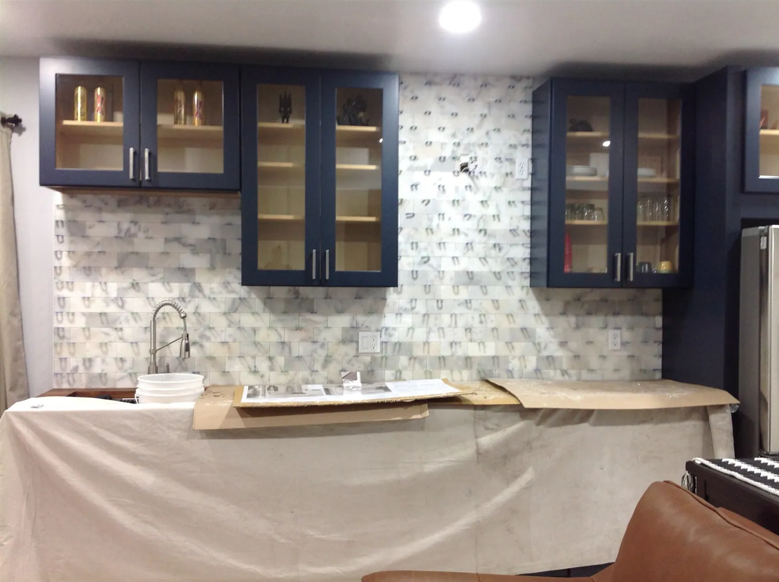 Kitchen with navy cabinets and glass mosaic backsplash