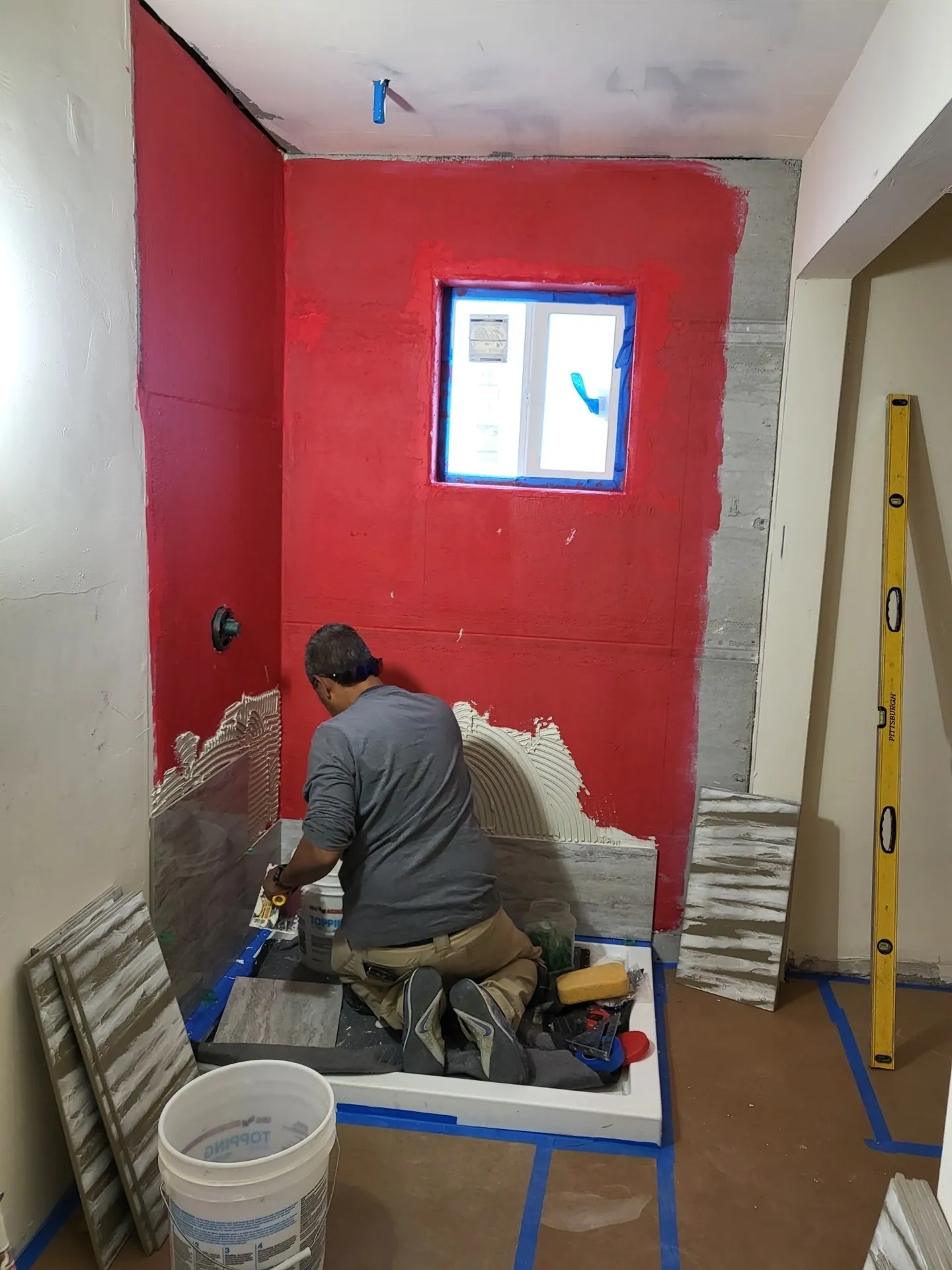 Installer tiling over waterproof membrane