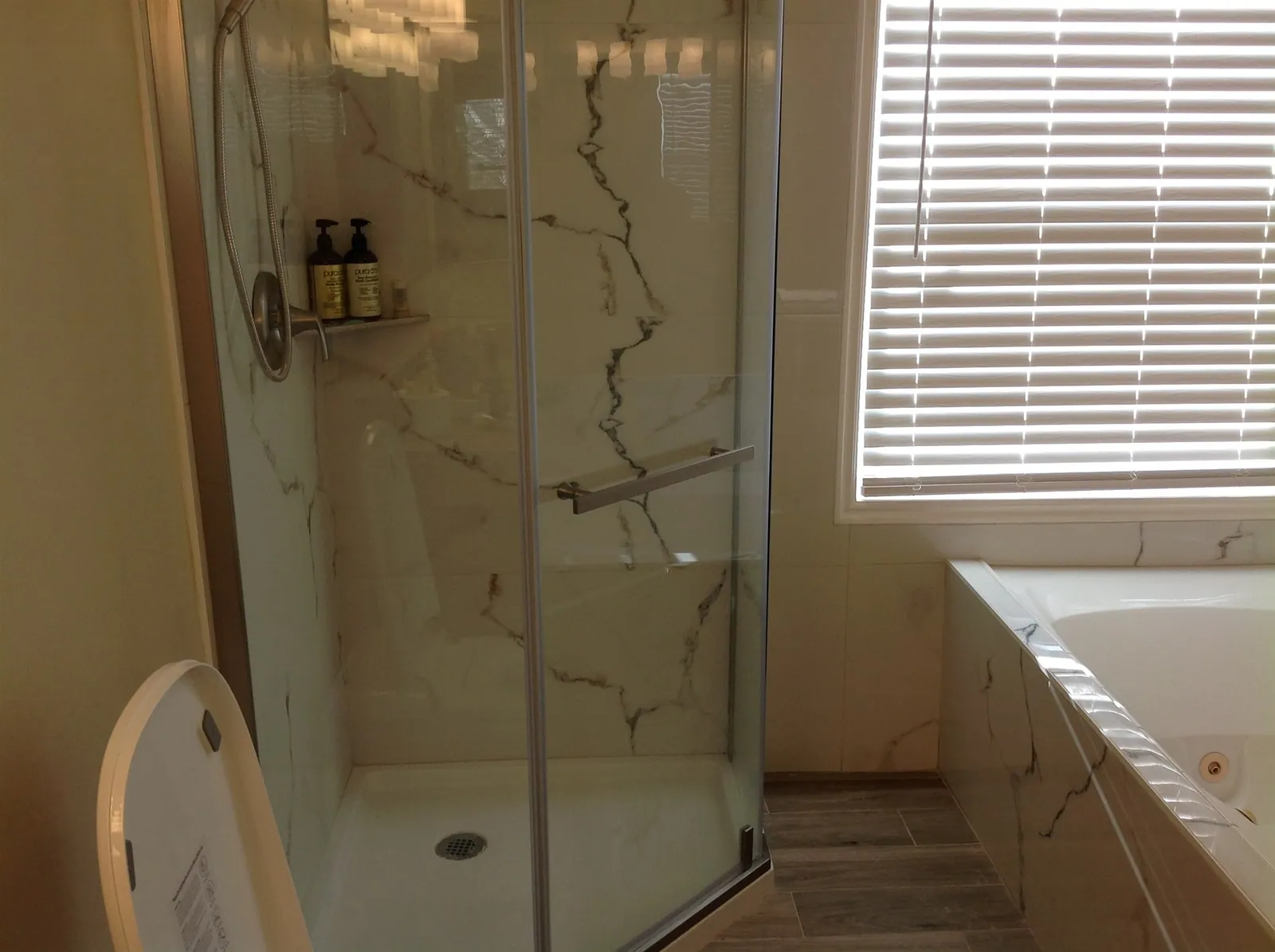 Neo-angle glass shower with marble-look slab walls