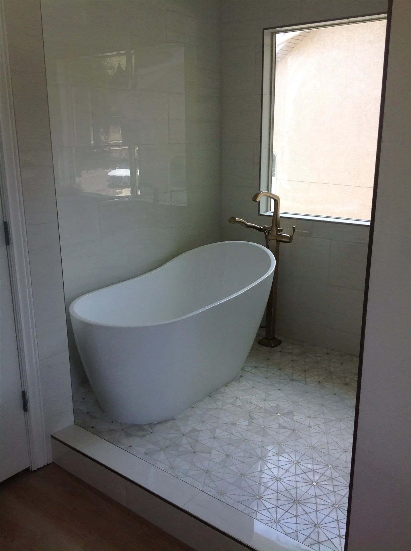 Freestanding tub with gold floor filler and mosaic tile
