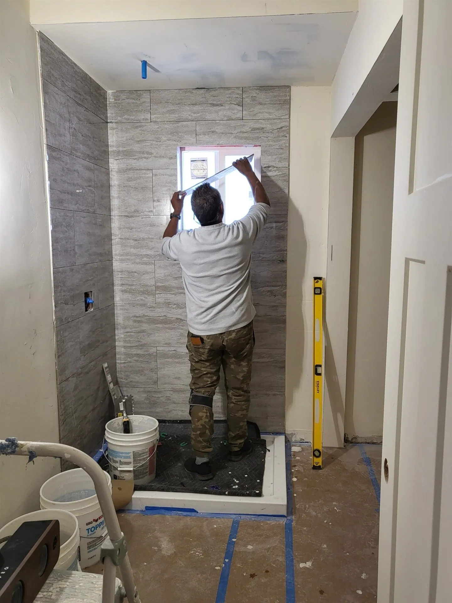 Installer setting large format wall tile