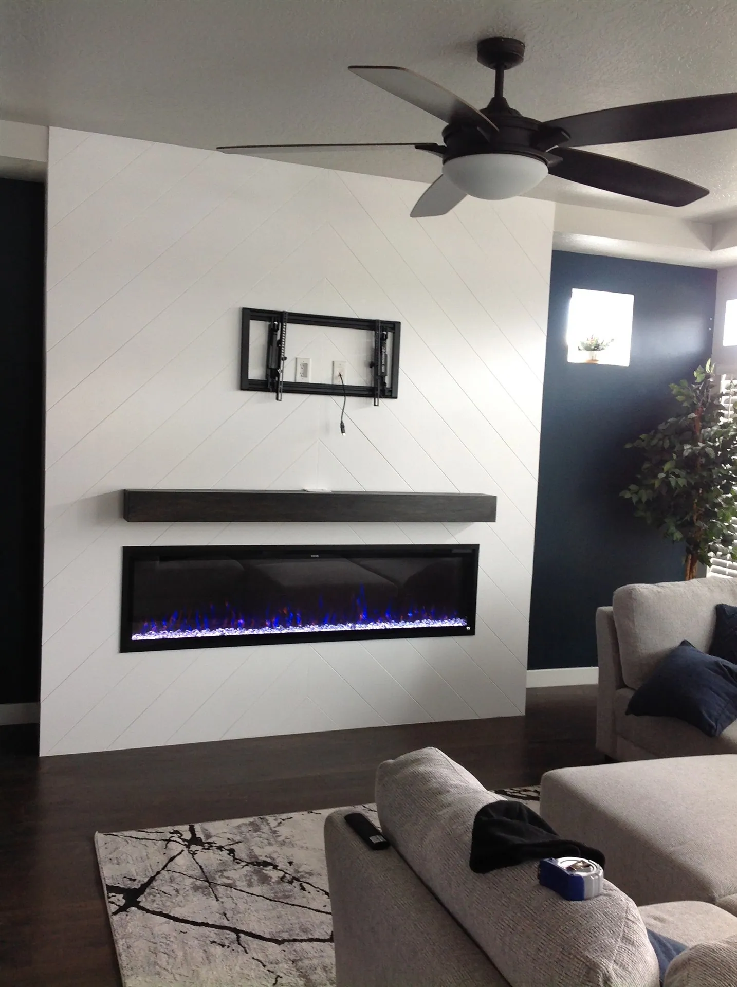 Living room with white shiplap wall and linear fireplace