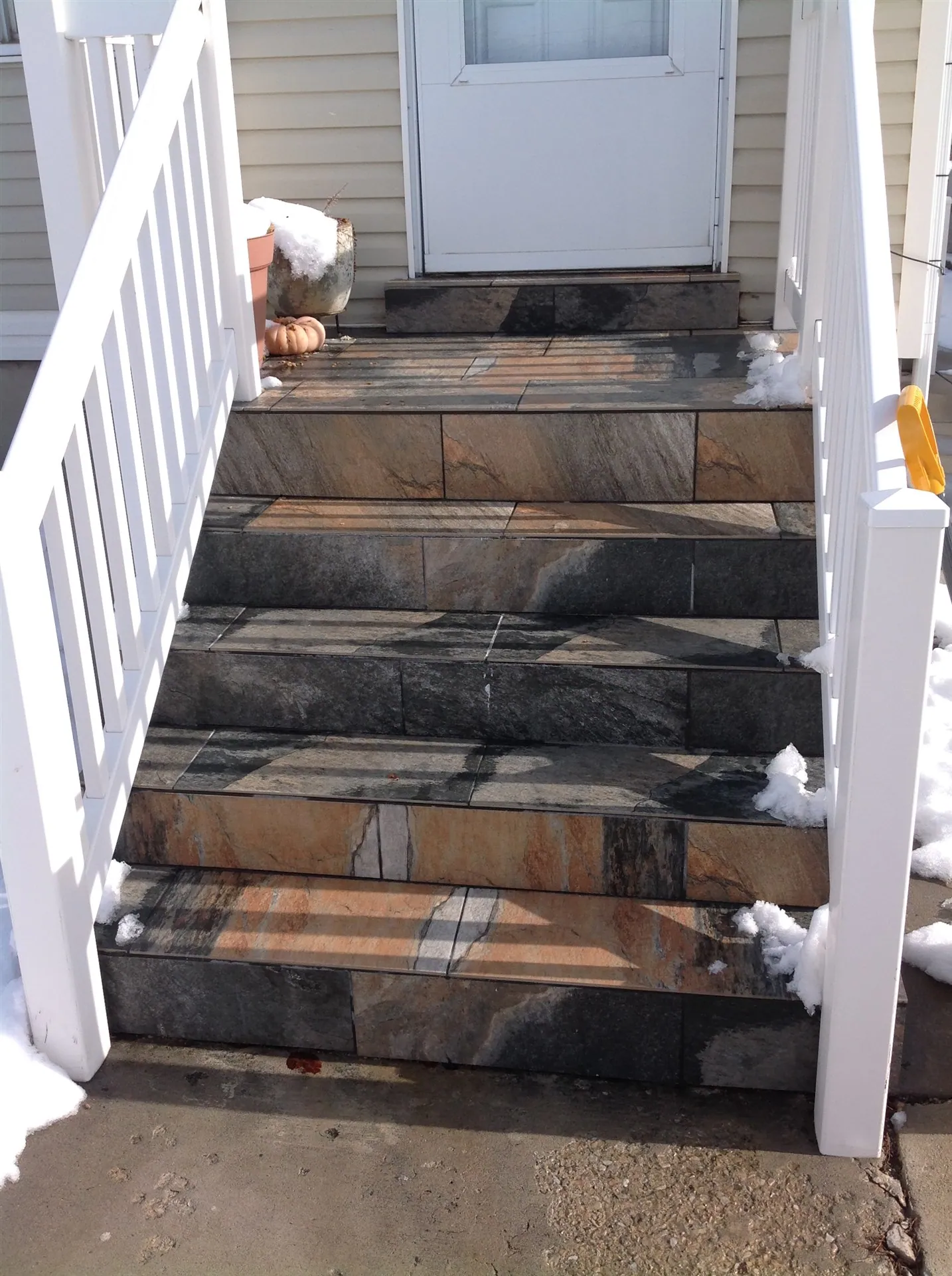 Exterior stone-clad entry stairs with railing