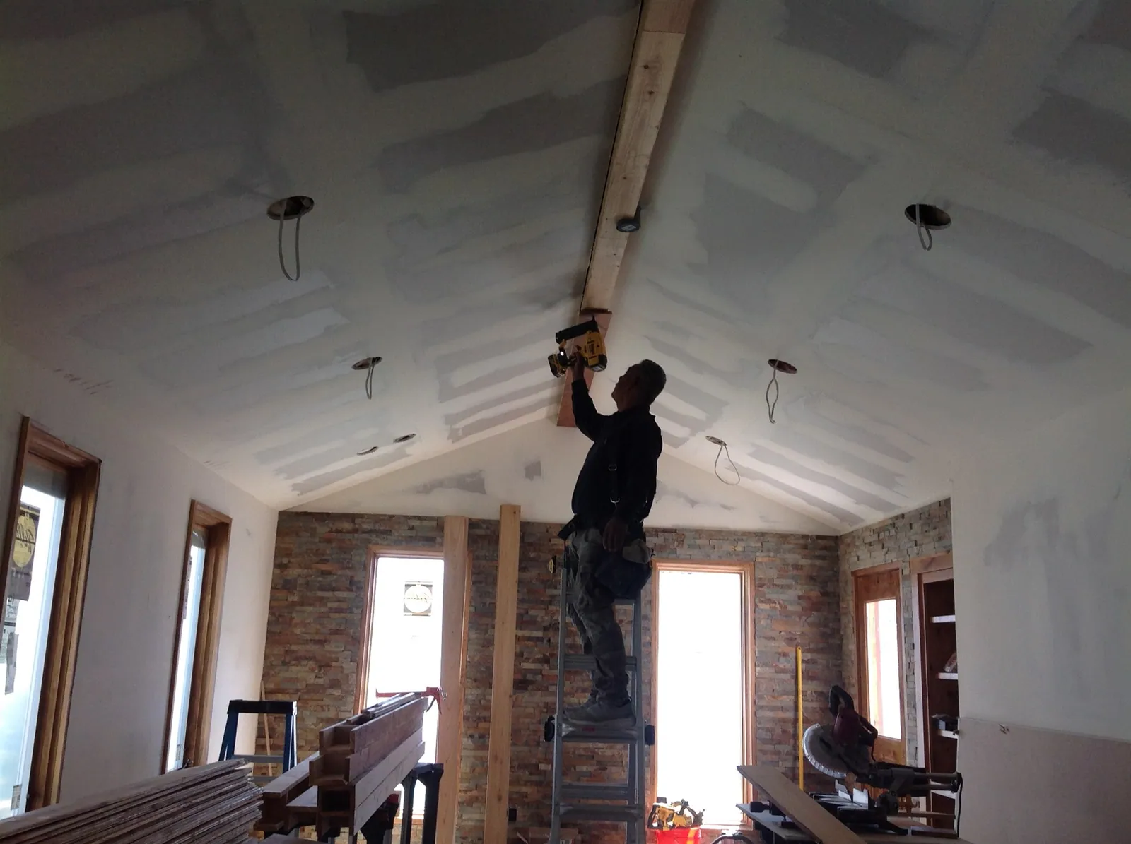 Installer finishing a vaulted drywall ceiling