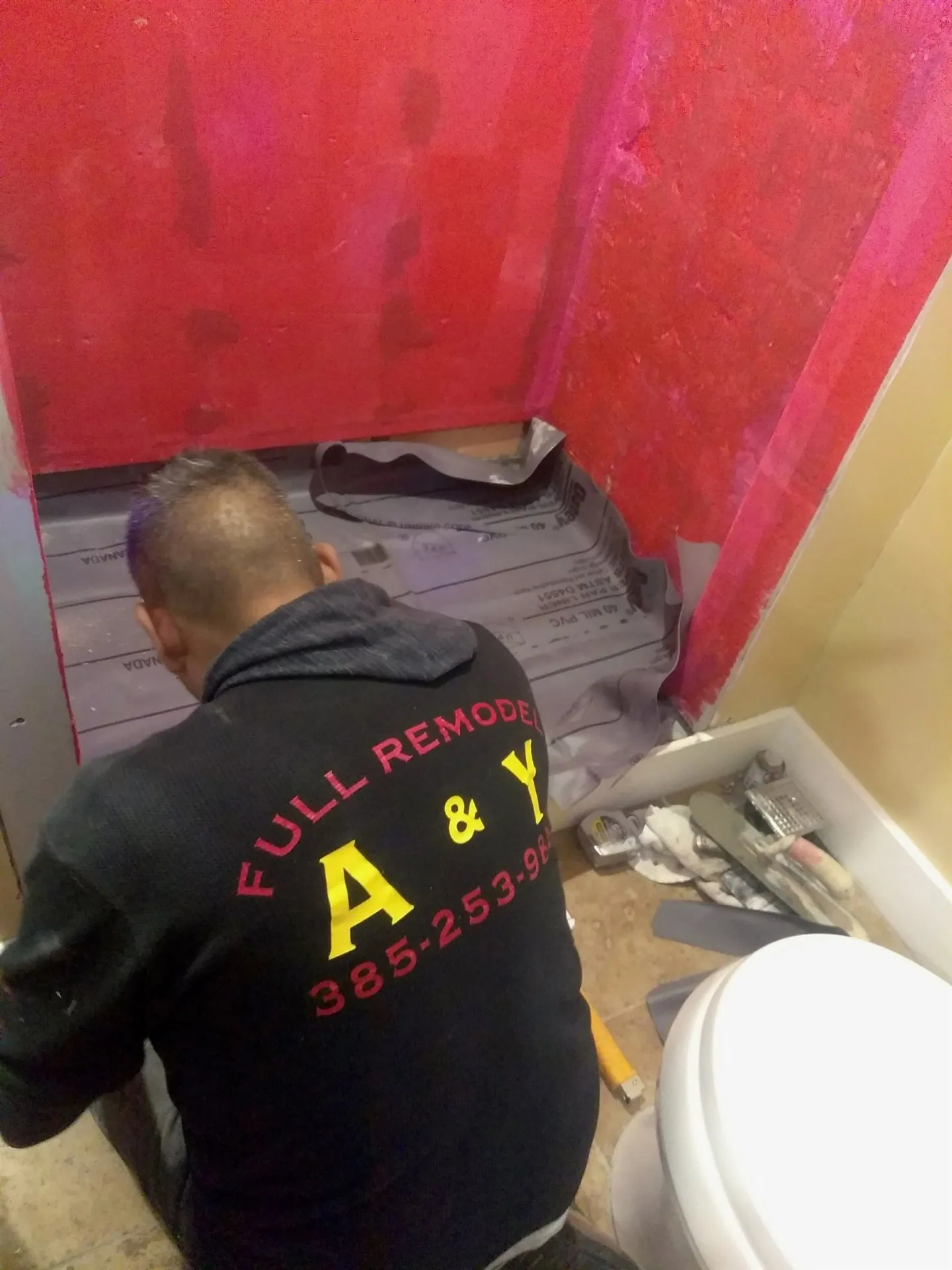 A and Y installer working on a waterproofed bathroom floor