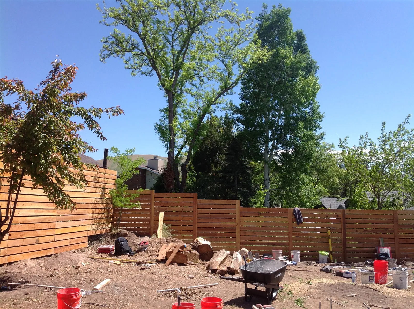 Horizontal slat privacy fence in a landscaped yard